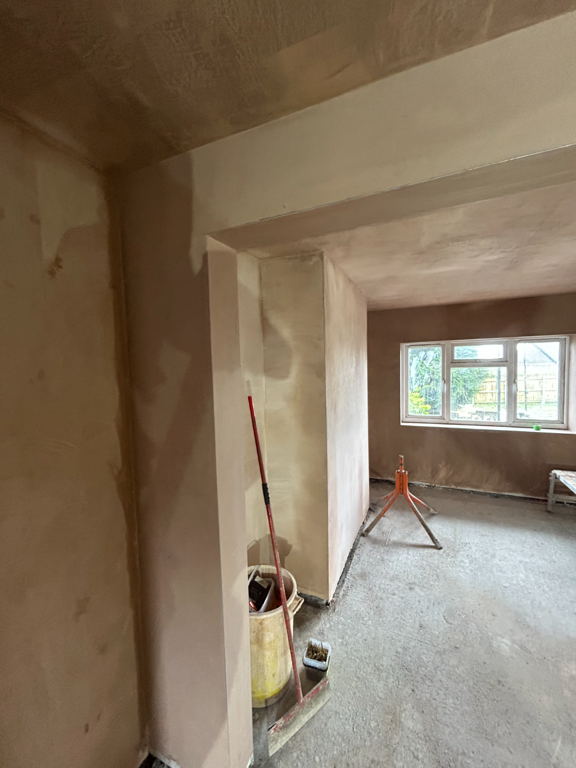 Plastered room with a wide opening through to the next