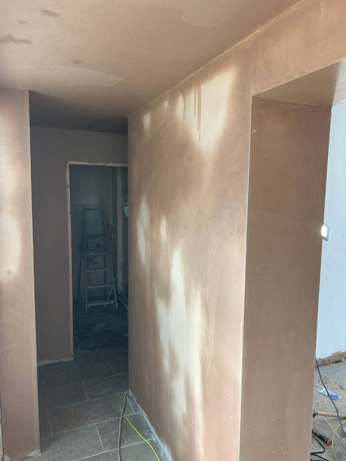Plastered hallway looking through to a doorway