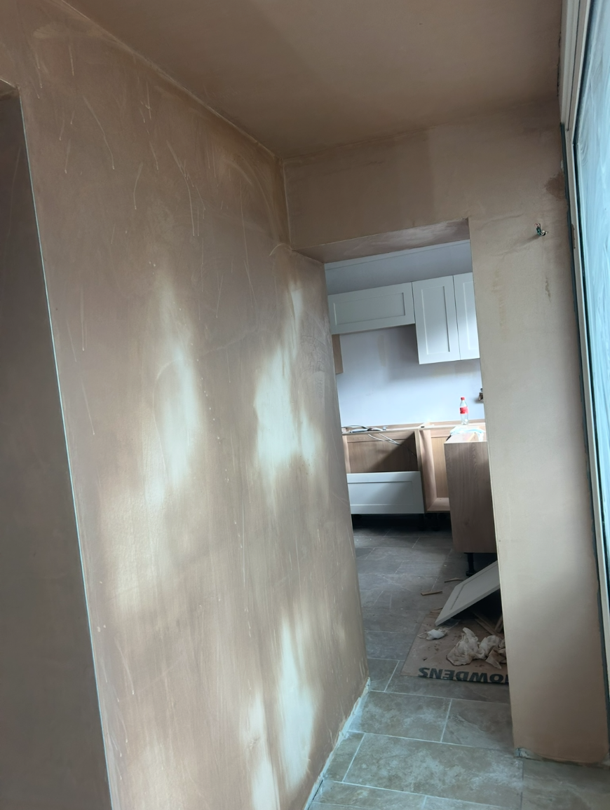 Plastered doorway opening looking into a further room