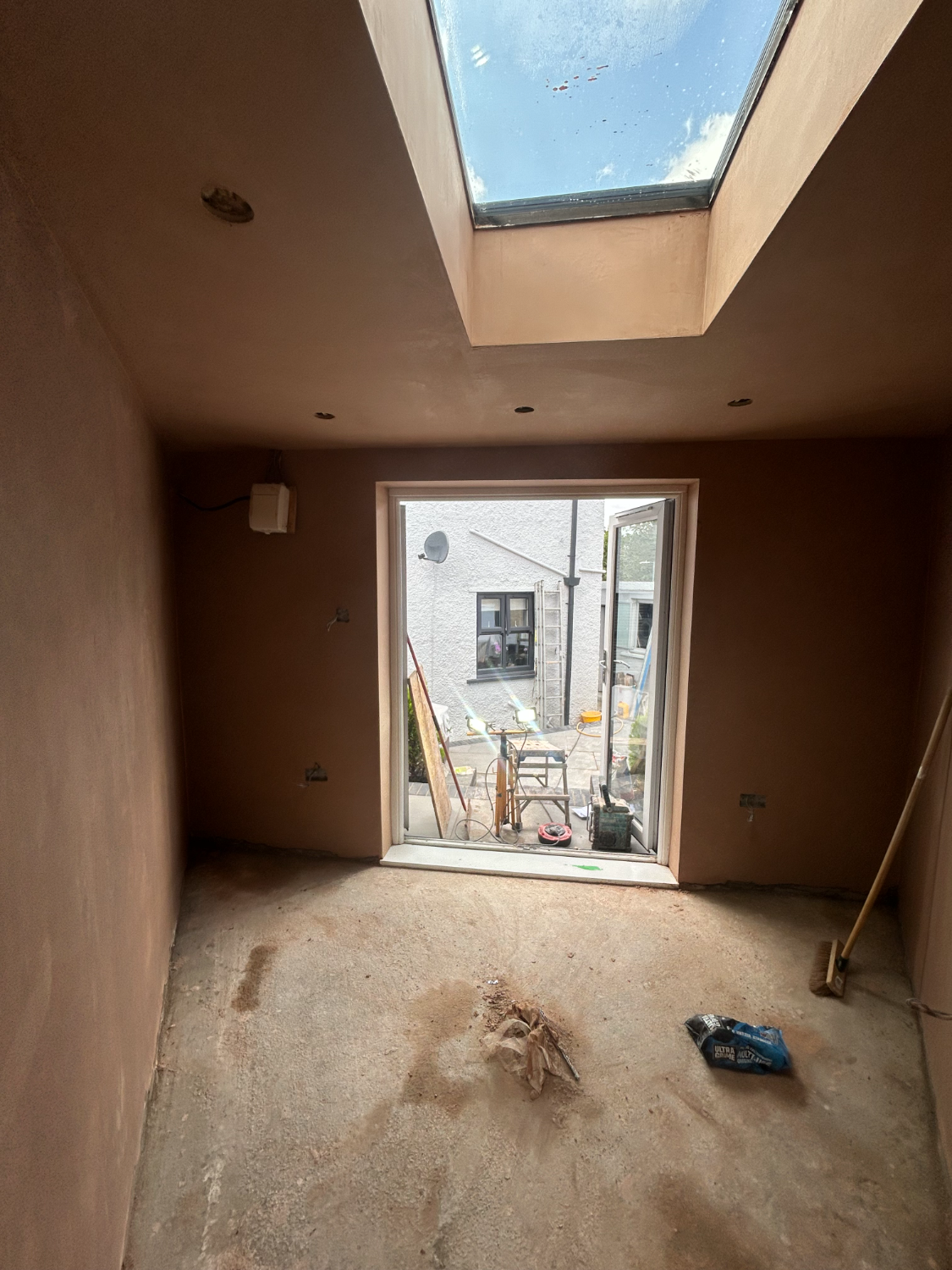 Room with skylight and patio door opening, plastered