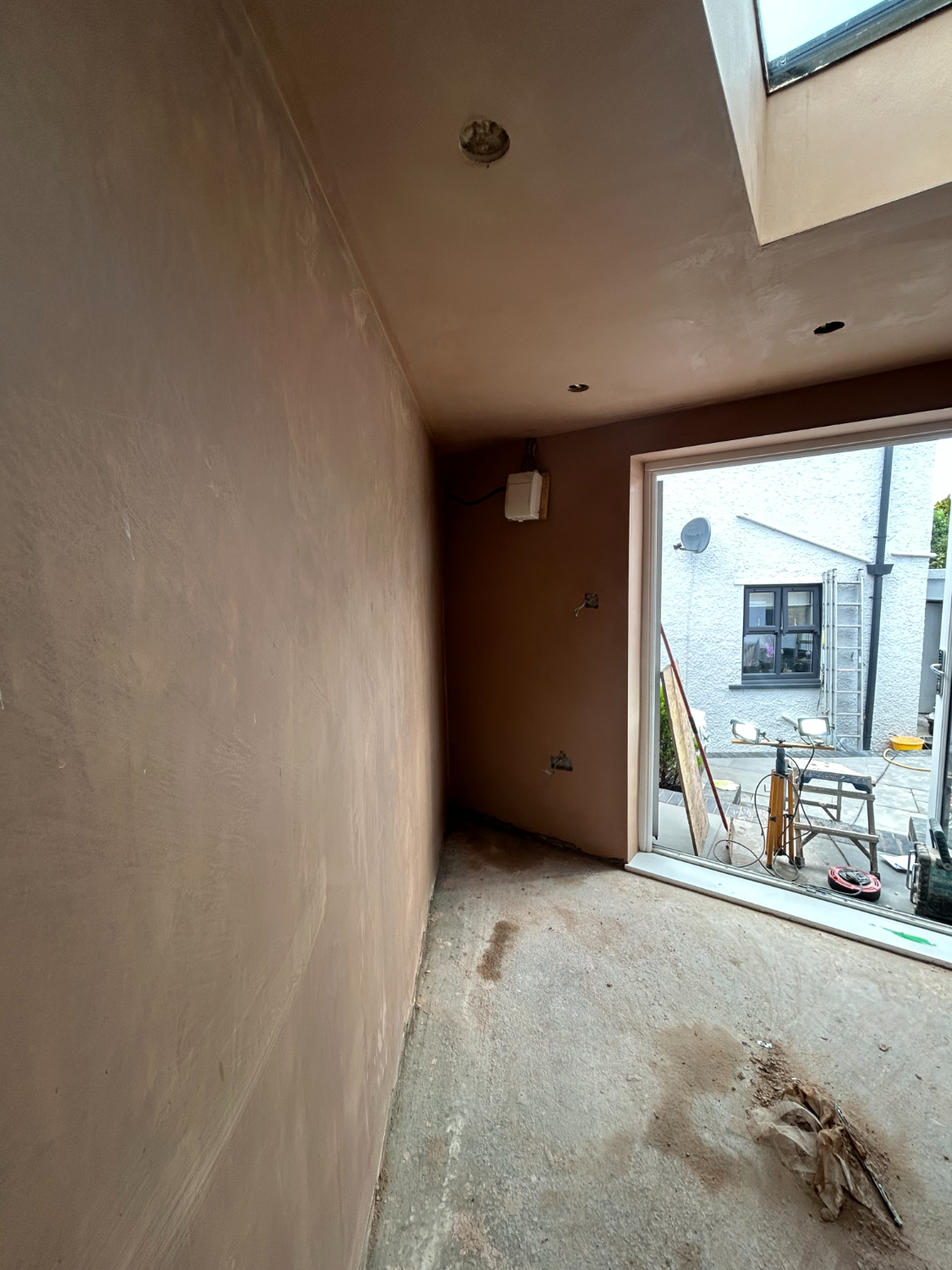Room with a large opening finished in plaster